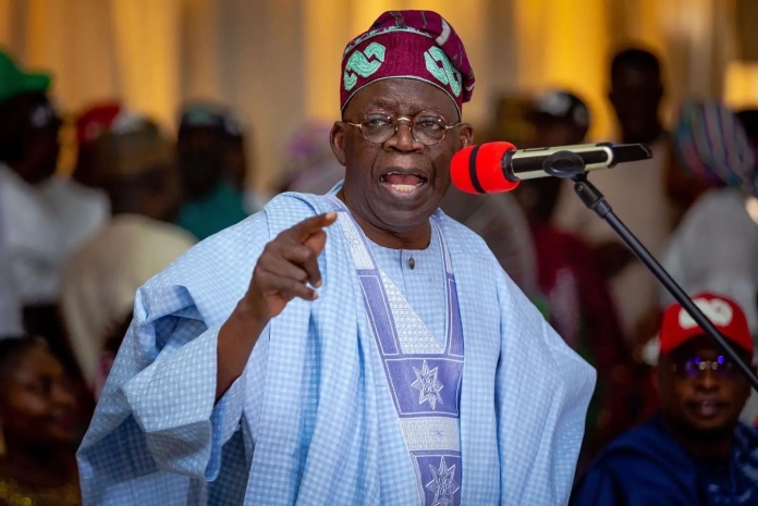 Bola-Tinubu-1 Nigerian President Bola Ahmed Tinubu speaking during a rally in Abuja. Dressed in traditional agbada attire, he passionately defends his political vision amid growing criticism.