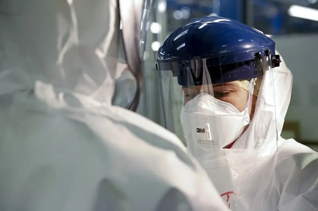 Healthcare workers check their protective equipment against Ebola during a training session