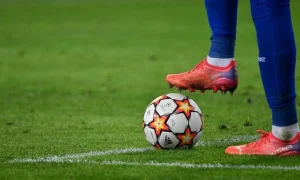 Un joueur qui a un pied sur un ballon de foot