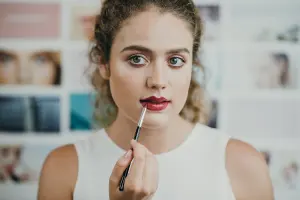 Femme appliquant un rouge à lèvres foncé