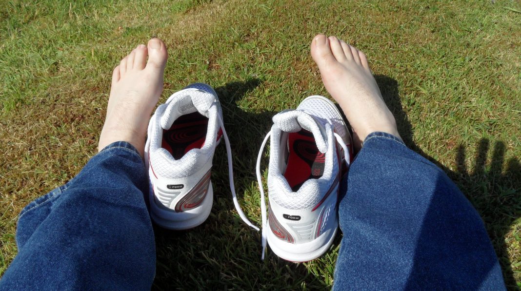 Paire de baskets posée près de pieds nus