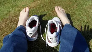 Paire de baskets posée près de pieds nus