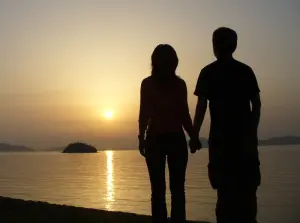 Silhouette d’un couple se tenant la main au coucher du soleil