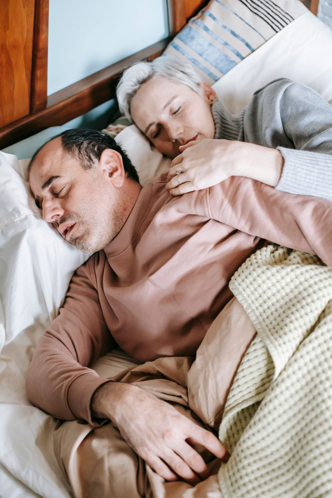 Un couple endormi dans un lit, illustration du lien entre sommeil et habitudes de vie