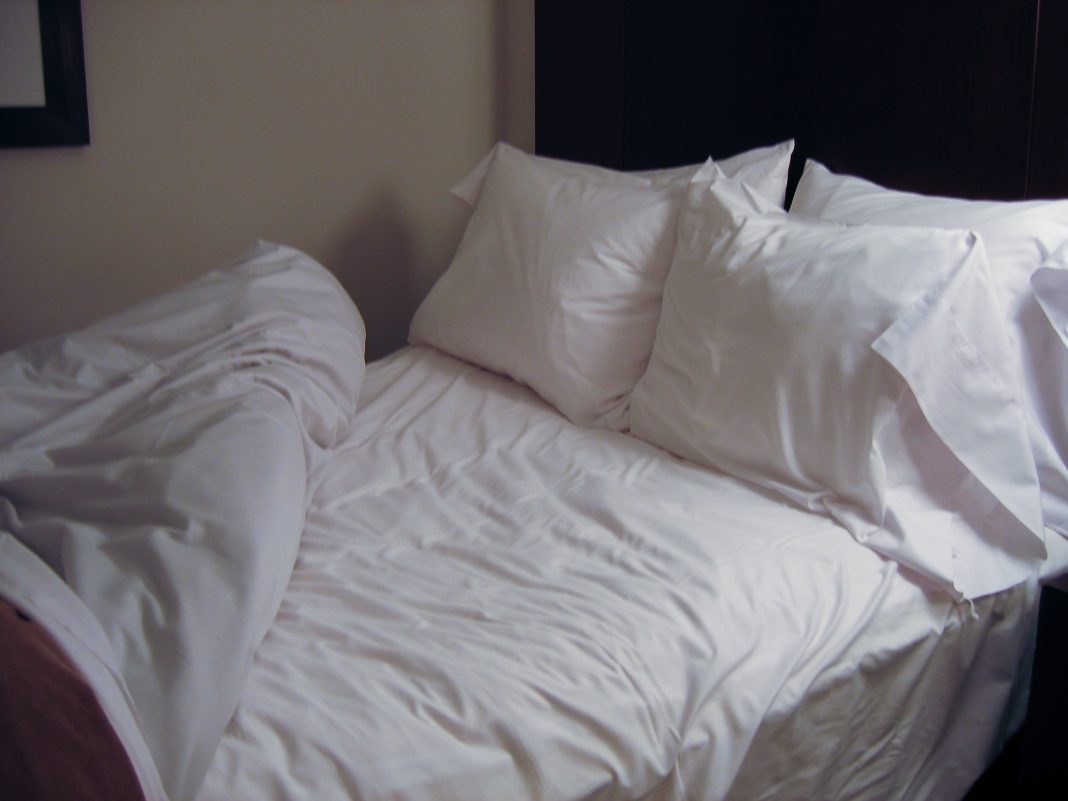 Lit avec draps blancs, illustration d’un linge de lit respirant