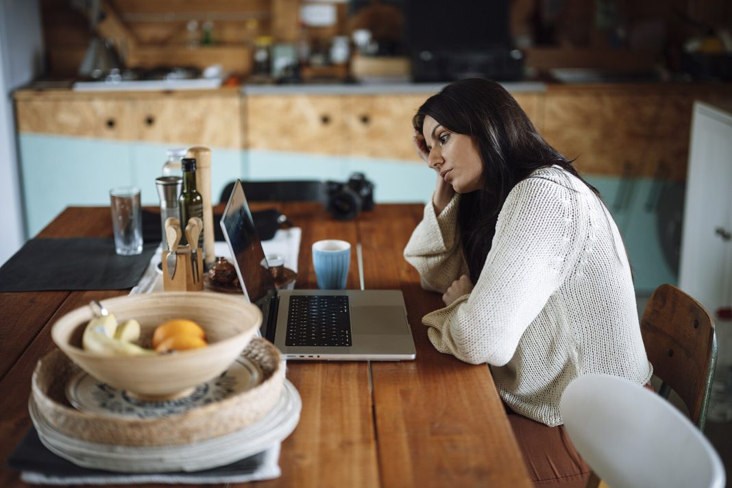 Femme fatiguée assise devant un ordinateur