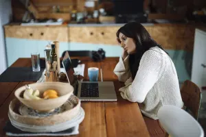 Femme fatiguée assise devant un ordinateur