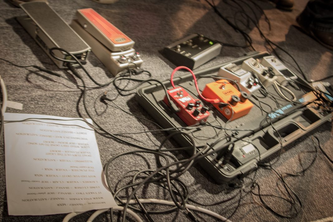 Guitare électrique et pédales d’effets sur une scène de concert