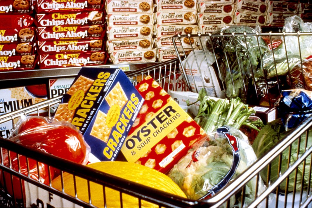 Encas, fruits et aliments disposés dans un panier de courses