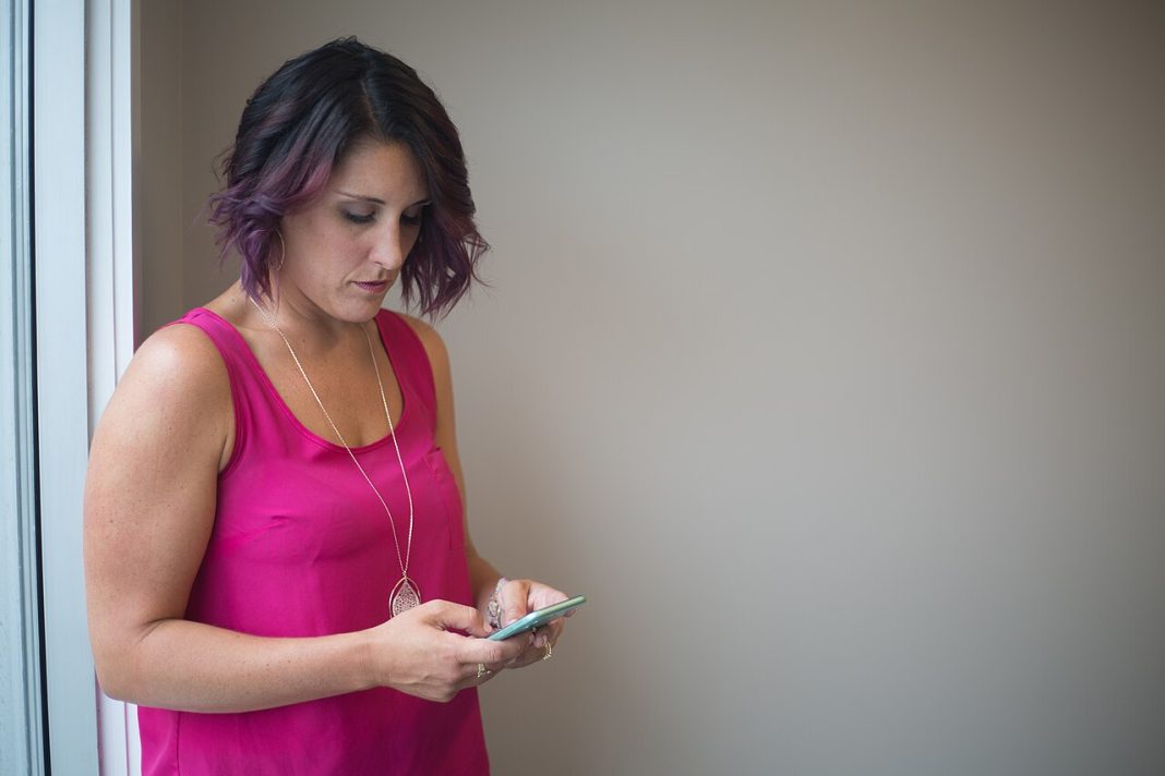 Femme consultant son smartphone, illustration des influenceuses IA et de la comparaison sur les réseaux sociaux