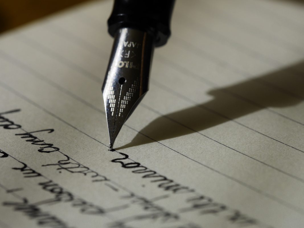 Gros plan d’un stylo-plume écrivant une lettre manuscrite
