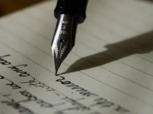 Gros plan d’un stylo-plume écrivant une lettre manuscrite