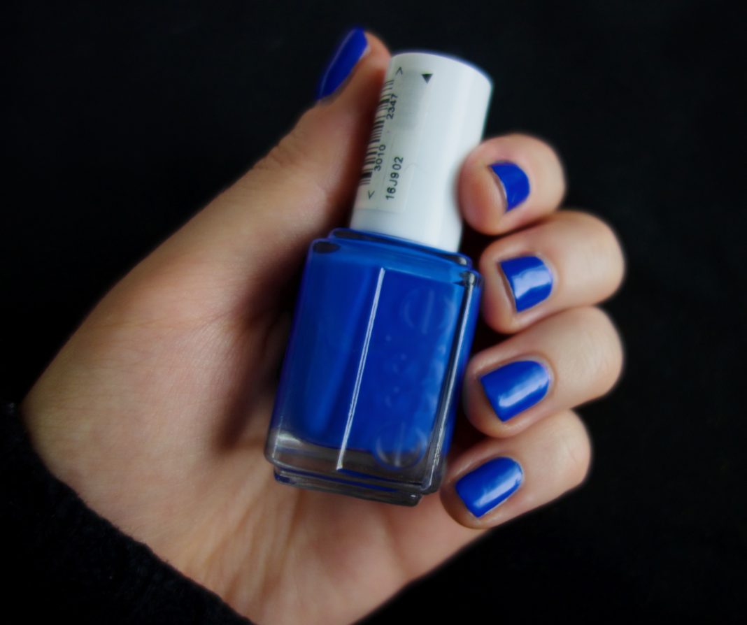 Ongles peints en bleu avec un flacon de vernis, illustration de la tendance manucure bleu glacé