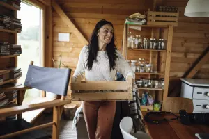 Femme transportant une caisse pour illustrer la méthode du faux déménagement et le désencombrement