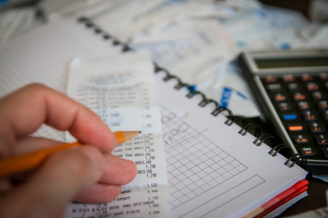 Calculatrice, billets et notes pour suivre un budget du quotidien