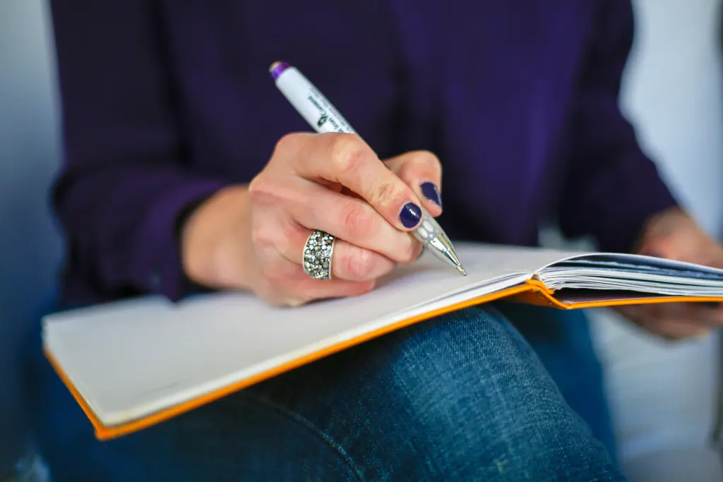 Femme écrivant dans un carnet pour organiser ses pensées du soir