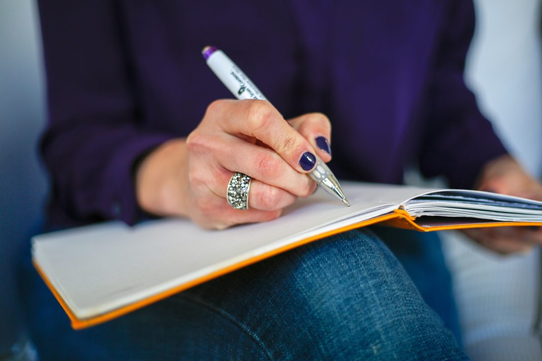 Femme écrivant dans un carnet pour organiser ses pensées du soir