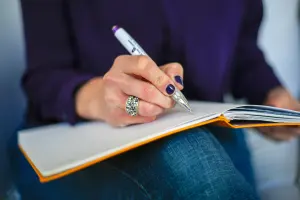 Femme écrivant dans un carnet pour organiser ses pensées du soir