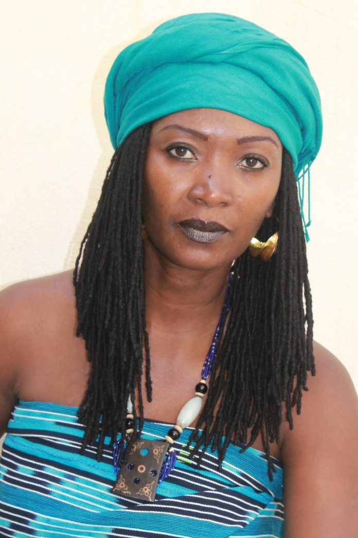 Femme portant un pagne traditionnel akan et des parures de Côte d’Ivoire