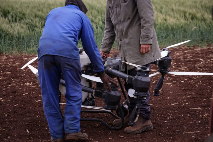 Deux agriculteurs utilisant un drone pour la surveillance des cultures