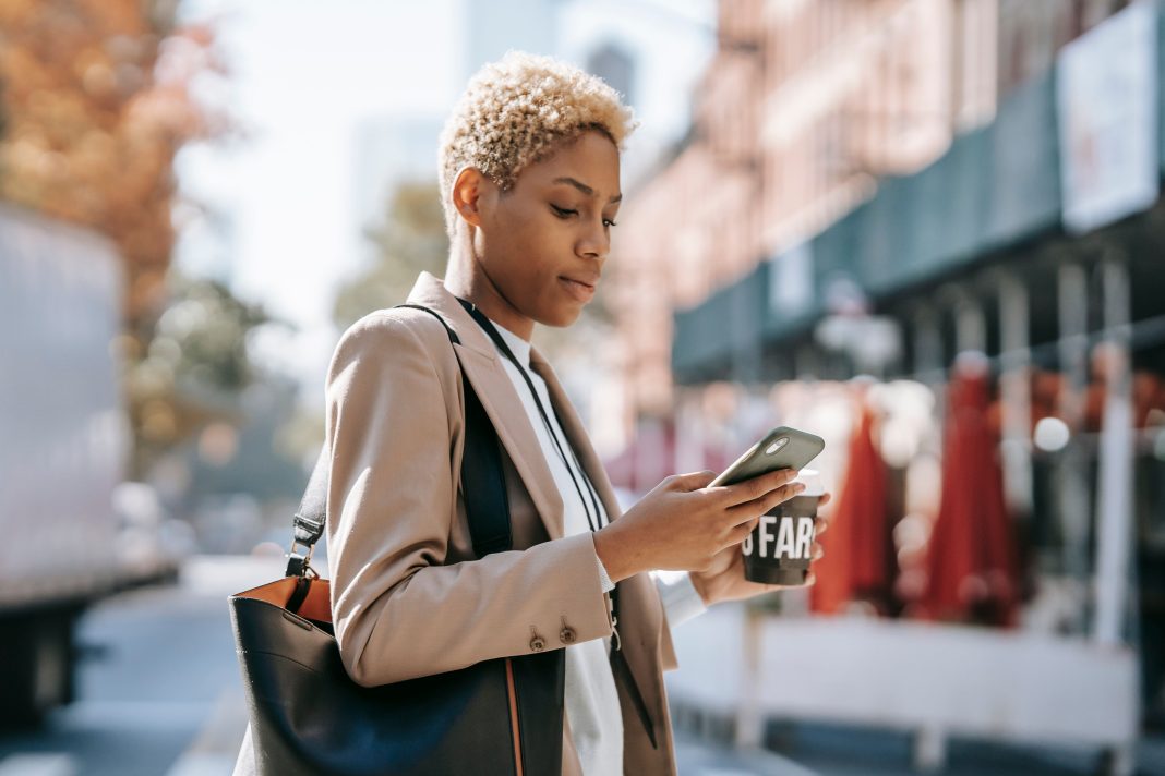 Femme tenant un smartphone et un café, illustration de la tendance girl grip