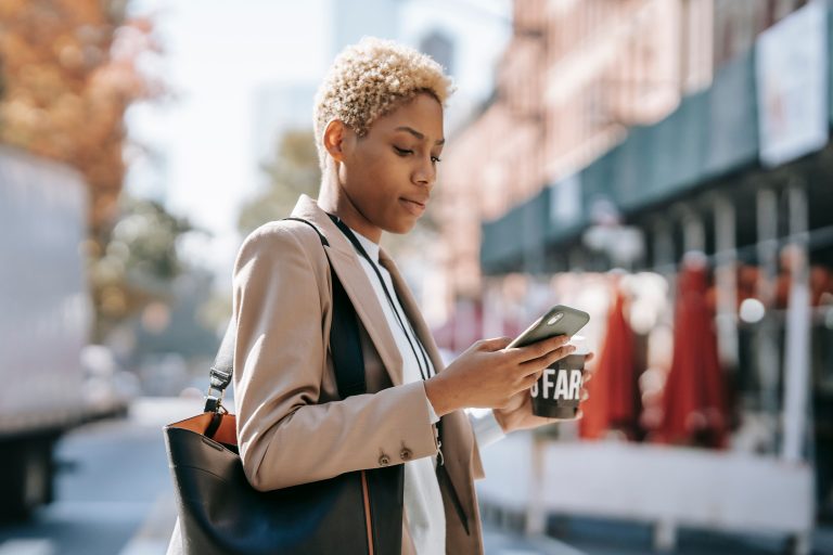 Femme tenant un smartphone et un café, illustration de la tendance girl grip