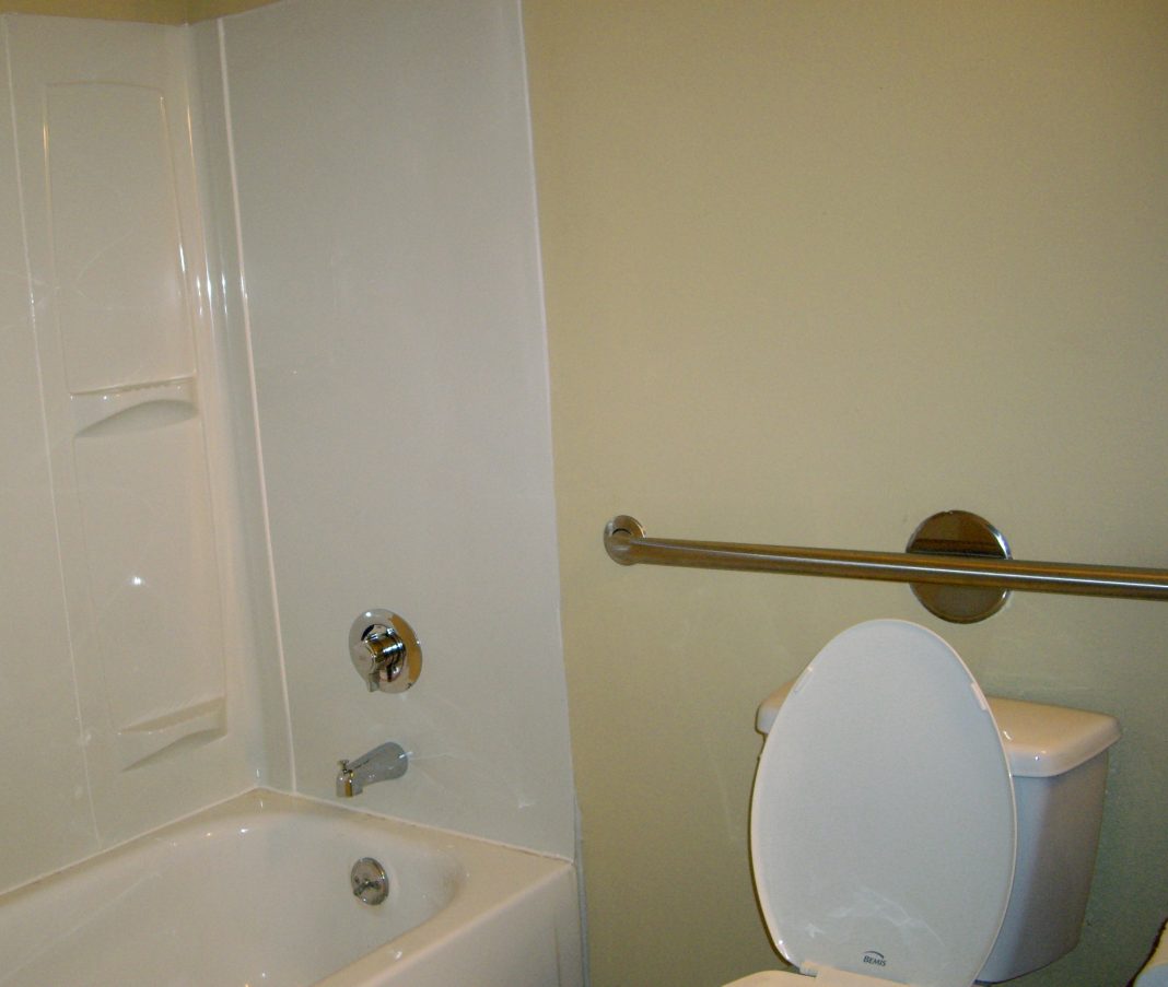 Salle de bains équipée d’une barre d’appui près des toilettes et de la douche