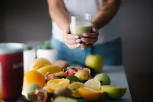 Un verre de smoothie vert entouré de fruits frais
