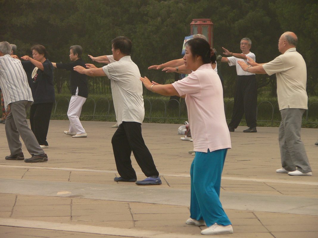 Groupe de personnes pratiquant le tai-chi en extérieur, image d’illustration