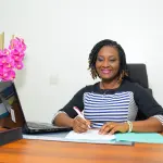 Une entrepreneure ivoirienne signe des documents dans un bureau
